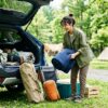 キャンプ道具を車に積み込む準備をしている様子